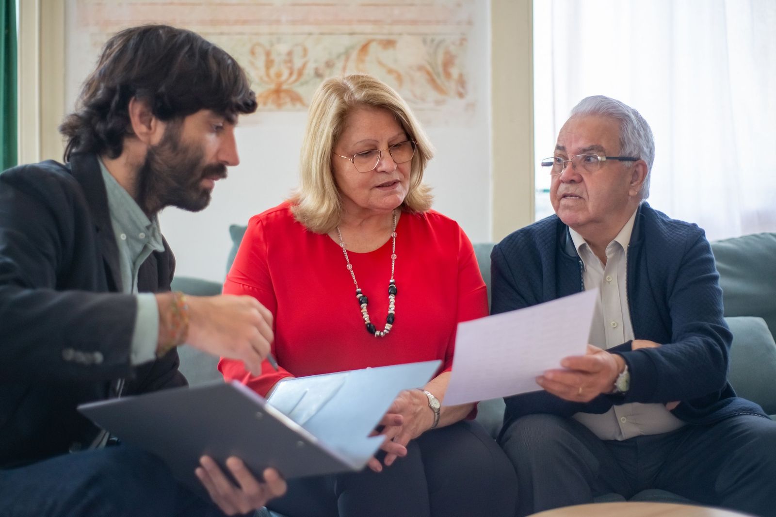 Un profesional revisando documentos con una pareja mayor