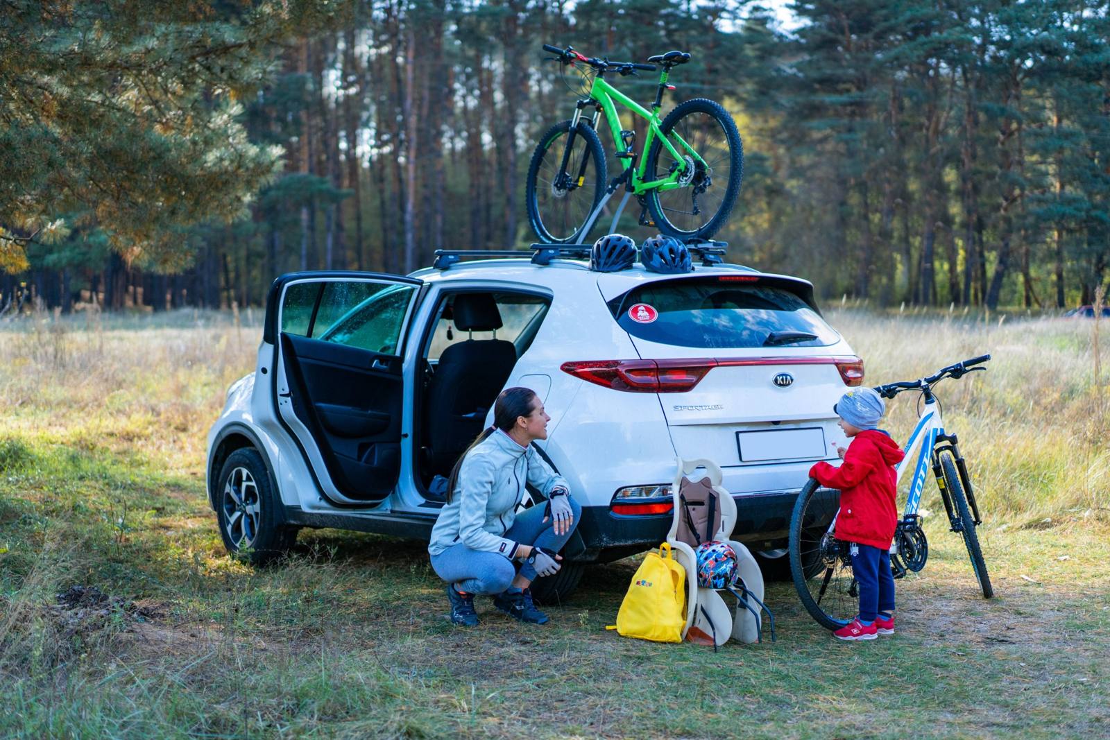 Una madre y su hijo preparándose para andar en bicicleta junto a su camioneta