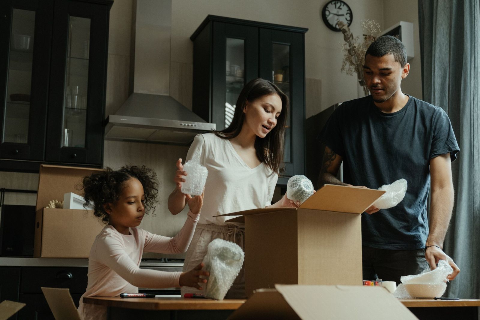 Una familia desempacando cajas de mudanza en su nueva cocina