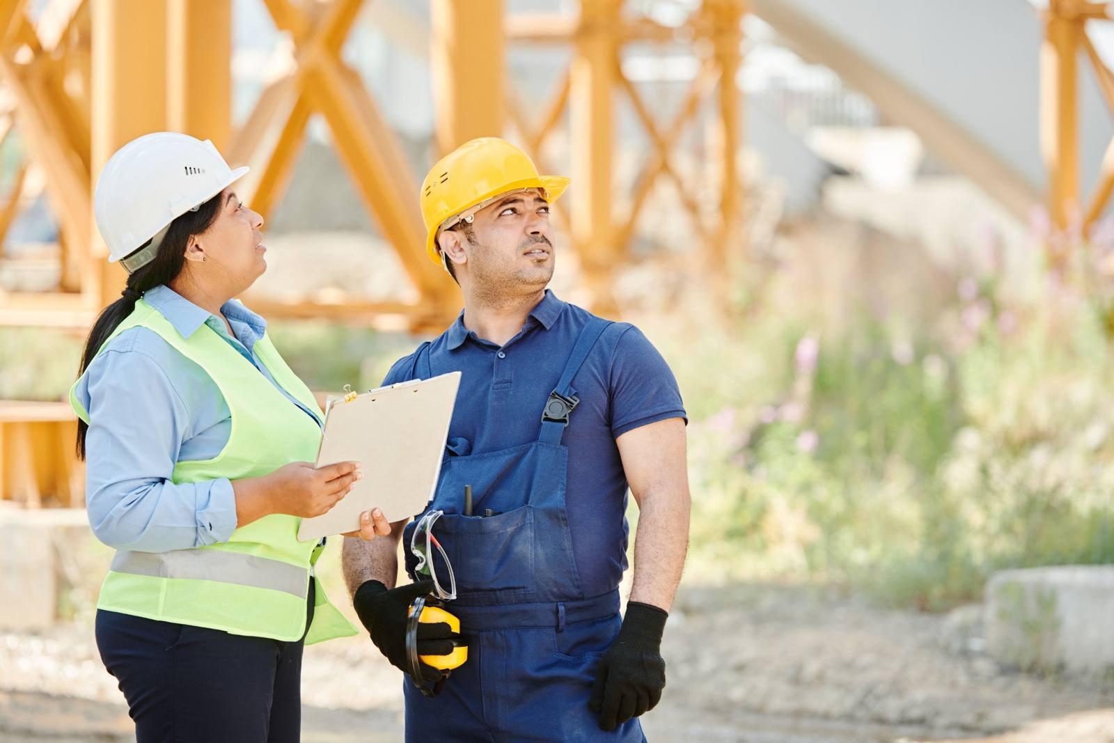 Una supervisora y un trabajador revisando una obra