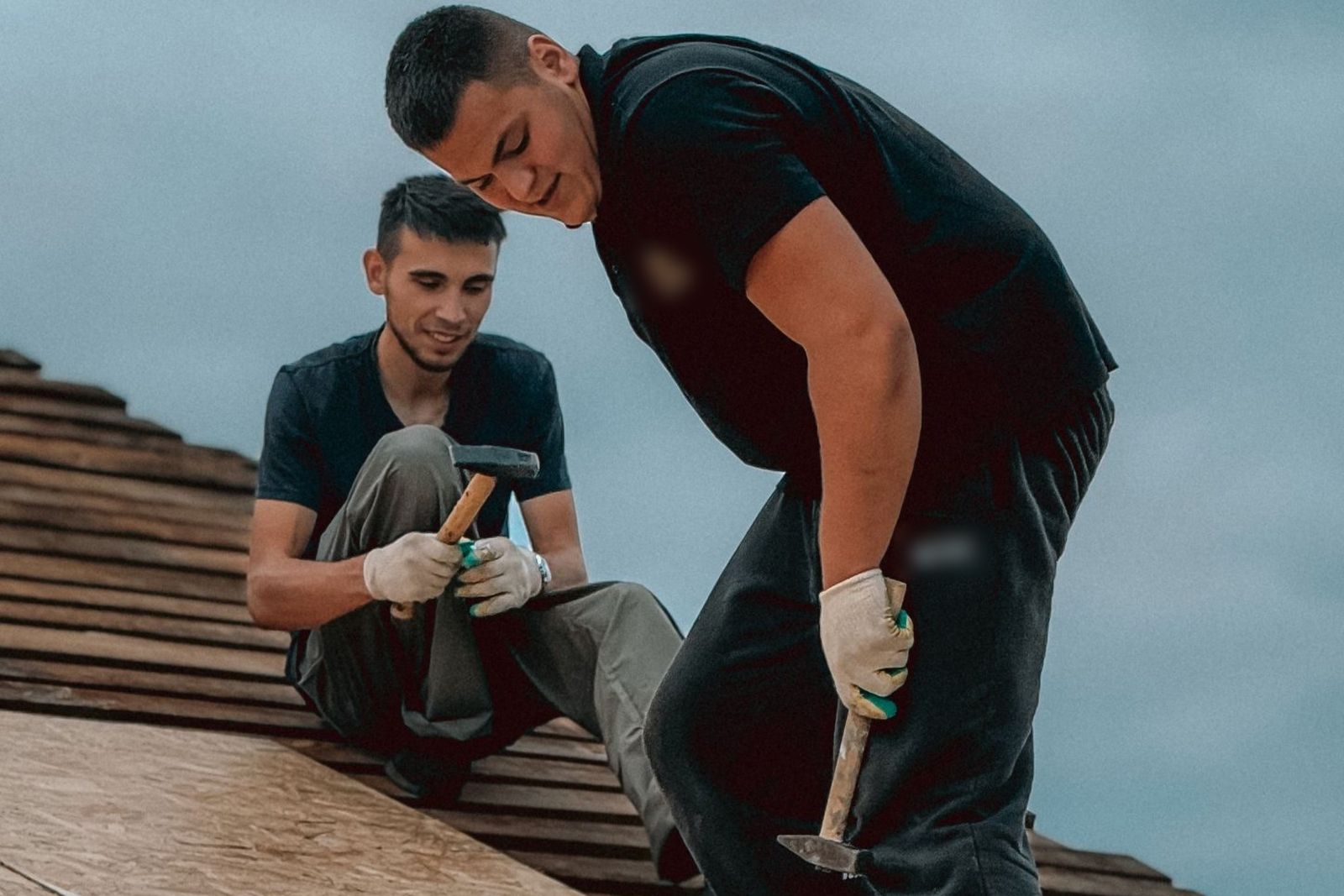 Dos techadores clavando el entablado de un techo
